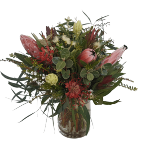 short glass vase arrangement filled with native flowers including protea blushing bride grevillea wax flower and eucalyptus